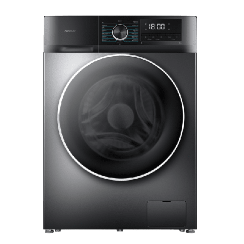 Vista de la cocina reformada de Casa Buen Camino en Arzúa. Se observan muebles y armarios superiores de color blanco impecable, encimera de granito veteado, placa de inducción, horno y microondas encastrados. Una mesa de madera clara con bancos ocupa el primer plano y una ventana al fondo ilumina toda la estancia con luz natural y vistas al jardín.